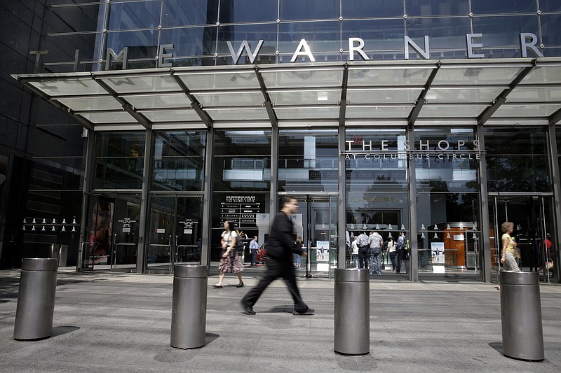 In this Tuesday, May 26, 2015 file photo, pedestrians walk by an entrance to the Time Warner Center in New York. On Saturday, Oct. 22, 2016, several reports citing unnamed sources said AT&T is in advanced talks to buy Time Warner, owner of the Warner Bros. movie studio as well as HBO and CNN. The giant phone company is said to be offering $80 billion or more, a massive deal that would shake up the media landscape. (AP Photo/Mary Altaffer)