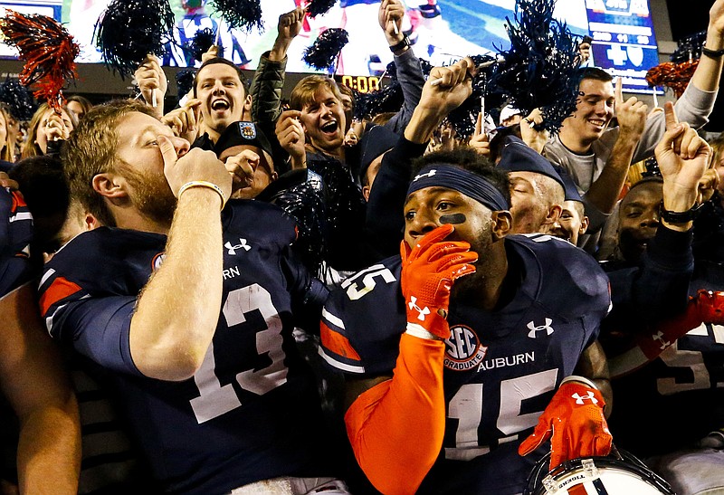 Auburn quarterback Sean White (13) and defensive back Joshua Holsey (15) celebrate after they defeated Arkansas 56-3 in an NCAA college football game, Saturday, Oct. 22, 2016, in Auburn, Ala. (AP Photo/Butch Dill)