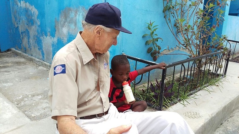 
              In this undated photo provided by Remote Area Medical, Remote Area Medical founder Stan Brock sits with a young Haitian boy in western Haiti, where RAM is participating in post-Hurricane Matthew relief efforts. (Eric Hutchinson/Remote Area Medical via AP)
            