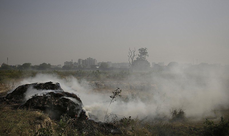 
              A heap of grass and garbage burns in a field on the outskirts of New Delhi, India, Saturday, Oct. 22, 2016. The Indian capital, laboring under the label of being the world's most polluted city, is trying something new to help clean up its air. A smartphone application that allows citizens to report the presence of construction dust or the burning of leaves and garbage in public parks to authorities was launched Friday. (AP Photo/Altaf Qadri)
            