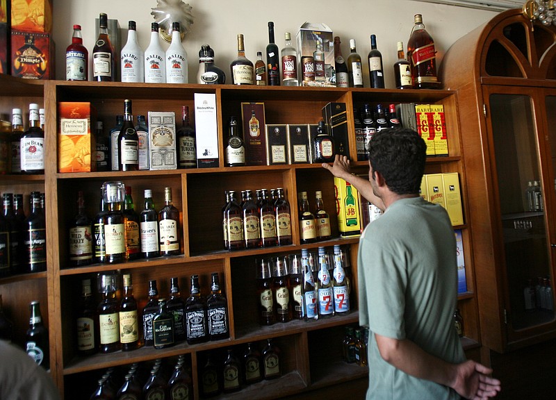 
              FILE -- In this Sept. 11, 2007, file photo, a man looks at bottles of alcohol on sale in liquor store in Baghdad, Iraq. Iraq's parliament passed a law forbidding the import, production or selling of alcoholic beverages. The bill passed late Saturday, Oct. 22, 2016, imposes a fine of up to 25 million Iraqi dinars, or $21,000, for anyone violating the ban. Islam forbids the consumption of alcohol, but it has always been available in Iraq's larger cities, mainly from shops run by Christians. It's unclear how strictly the law would be enforced. (AP Photo/ Hadi Mizban, File)
            