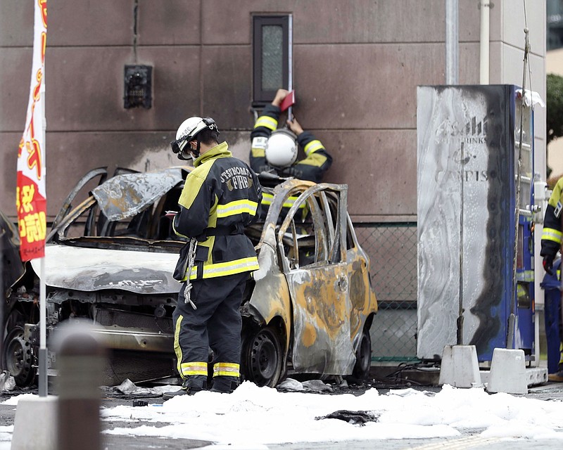 
              Firefighters investigate the scene where two cars caught on fire at a parking lot in Utsunomiya, north of Tokyo Sunday, Oct. 23, 2016. Police are investigating two apparent blasts, one at the parking lot and the other at a nearby public park, that happened back-to- back and left one person dead. (Yukie Nishizawa/Kyodo News via AP)
            