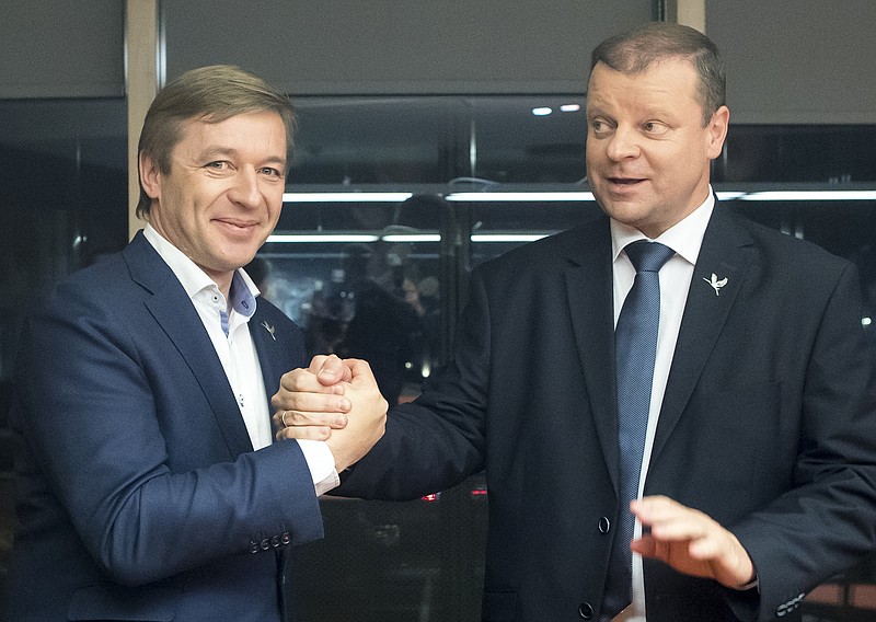 
              Lithuania's Peasant and Green's Union (LPGU) party leader Salius Skvernelis, right, and Lithuania's Peasant and Green's Union (LPGU) party Chairman Ramunas Karbauskis celebrats after winning the Lithuania's parliament election, in Vilnius , Lithuania in Vilnius, Lithuania, Sunday, Oct. 23, 2016. (AP Photo/Mindaugas Kulbis)
            