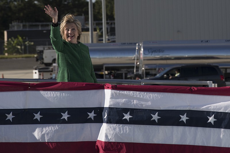 
              Democratic presidential candidate Hillary Clinton waves at reporters as she boards her campaign plane at an international airport, Sunday, Oct. 23, 2016, in Morrisville, N.C. (AP Photo/Mary Altaffer)
            