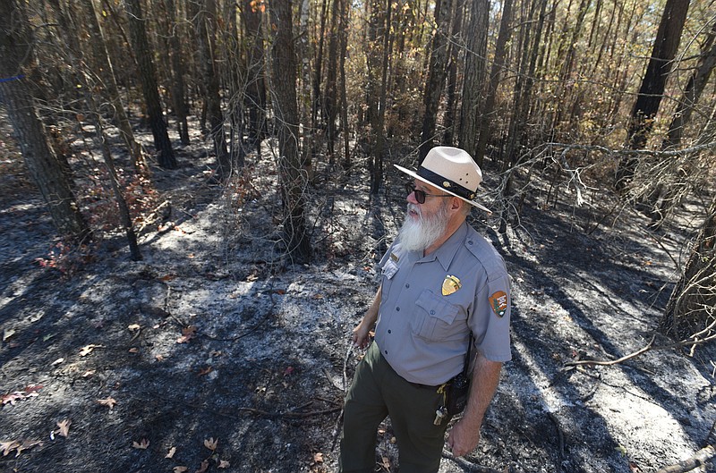 Interpretive park ranger Larry Beane talks to a homeowner near an area of burned woods Tuesday, October 25, 2015. A fire that started over the weekend tore through around 325 acres in Little River Canyon in Alabama.