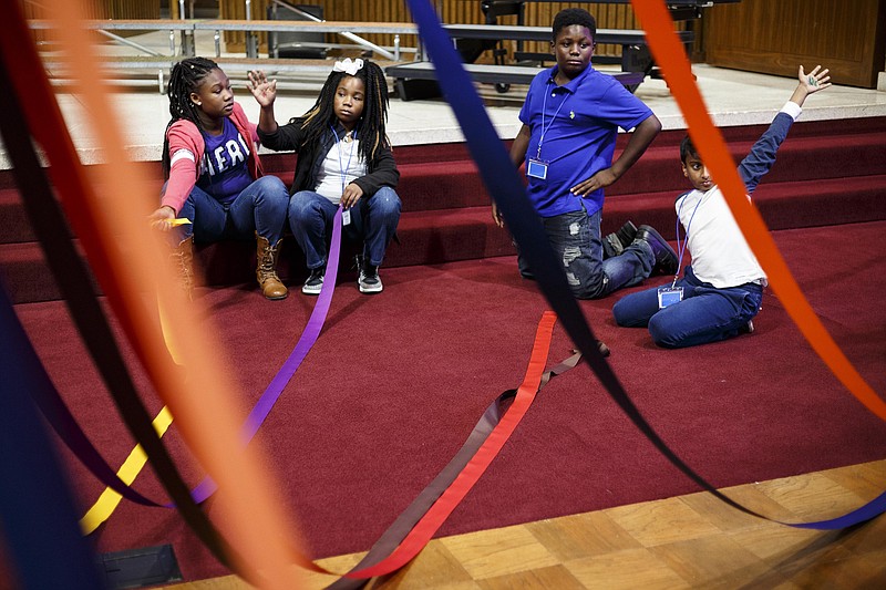 Alexiana Jackson, Aniyah Murray, Darrius Talley, and Nicholas George, from left, raise their hand while learning about a maypole at the 2nd annual HamiltonSings! event at First Baptist Church Golden Gateway on Tuesday, Oct. 25, 2016, in Chattanooga, Tenn. 47 Hamilton County Elementary Schools brought students for instructional classes in chorus, instrument, and dance over the day which concluded in a public performance in the evening.