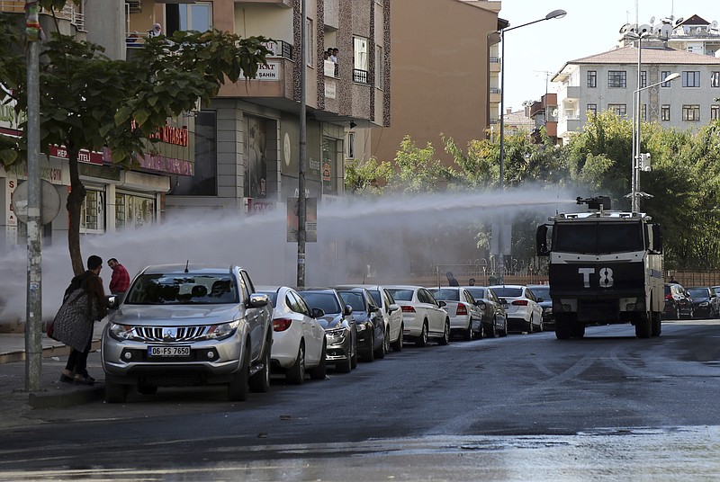 
              Police use water cannons against pro-Kurdish Peoples's Democratic Party members as they protest the detention of Gultan Kisanak, Diyarbakir Mayor, and co-mayor Firat Anli, in Diyarbakir, Turkey, Wednesday, Oct. 26, 2016. Turkish police on Wednesday used tear gas and water cannons to disperse hundreds of demonstrators protesting the detentions of two leading politicians in the largest city in the country's mainly-Kurdish southeast. About a thousand people gathered outside the Diyarbakir municipality to demand the release of Kisanak and Anli, who were taken into custody late Tuesday as part of a terrorism investigation.(AP Photo/Mahmut Bozarslan)
            