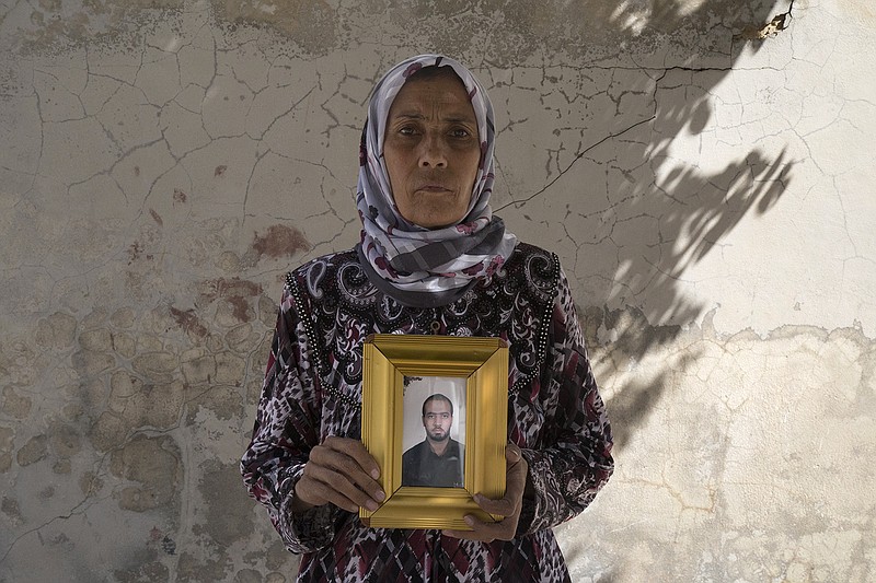 
              This picture released on Wednesday, Oct. 26, 2016 by the New York-based group Human Rights Watch, shows Zakia Hassan holds a photo of her son, Ibrahim Hammud, 35, who detonated an explosive device when he stepped on a mattress as he returned to his house in Manbij, Syria. Homemade landmines planted by the Islamic State group have killed and injured hundreds of civilians, including dozens of children, in the town of Manbij in northern Syria, Human Rights Watch says. (Ole Solvang, Human Rights Watch via AP)
            