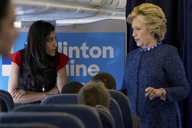 Democratic presidential candidate Hillary Clinton speaks with senior aide Huma Abedin aboard her campaign plane at Westchester County Airport in White Plains, N.Y., Friday, Oct. 28, 2016, before traveling to Iowa for rallies. (AP Photo/Andrew Harnik)