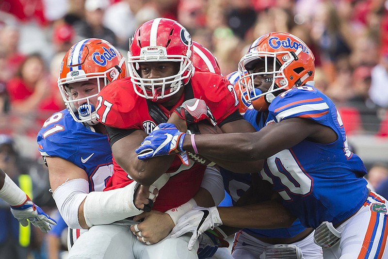 Florida defensive back Marcus Maye (20) and Florida defensive lineman Joey Ivie (91) tackle Georgia running back Nick Chubb (27) during the first half of an NCAA football game, Saturday, Oct. 29, 2016, in Jacksonville, Fla. (AP Photo/Stephen B. Morton)
