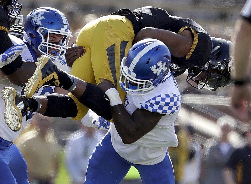 Missouri quarterback Marvin Zanders, top, is stopped by Kentucky safety Marcus McWilson after running for a short gain as Kentucky's Kash Daniel, left, gets in on the play during the first half of an NCAA college football game Saturday, Oct. 29, 2016, in Columbia, Mo. (AP Photo/Jeff Roberson)



