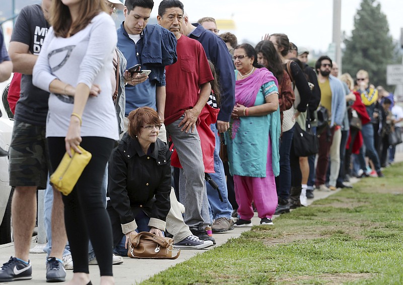 
              FILE - In this Oct. 30, 2016 file photo, a woman kneels to take a "back break" while waiting in line at a weekend early voting polling place at the North Hollywood branch library in Los Angeles. The FBI's disclosure that it was reviewing emails related to Hillary Clinton's email investigation will make no difference to tens of millions of voters who have already cast ballots.  (AP Photo/Reed Saxon, File)
            