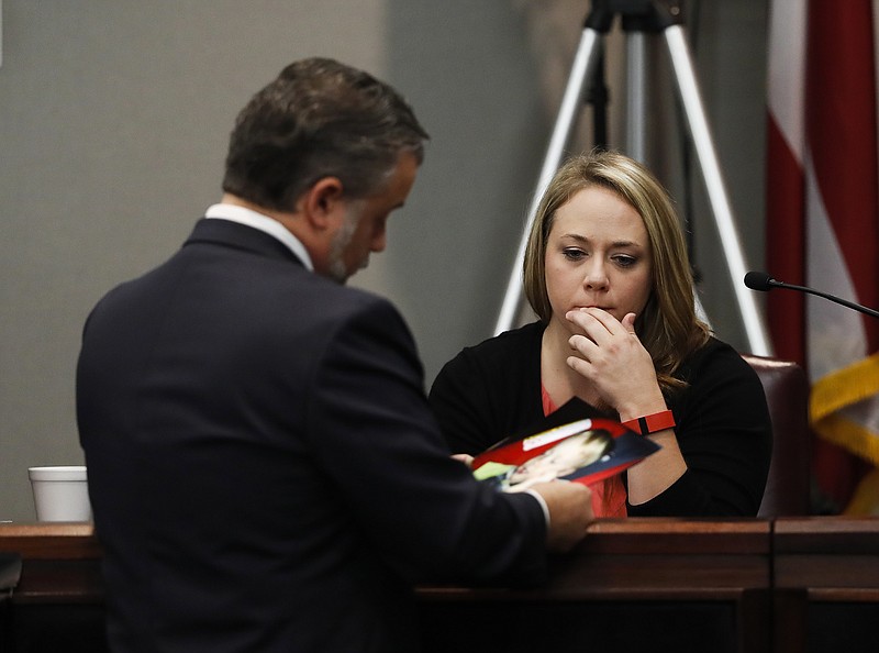 Leanna Taylor is shown photos of her son Cooper by defense attorny Maddox Kilgore during a murder trial for her ex-husband Justin Ross Harris who is accused of intentionally killing Cooper in June 2014 by leaving him in the car in suburban Atlanta, Monday, Oct. 31, 2016, in Brunswick, Ga.