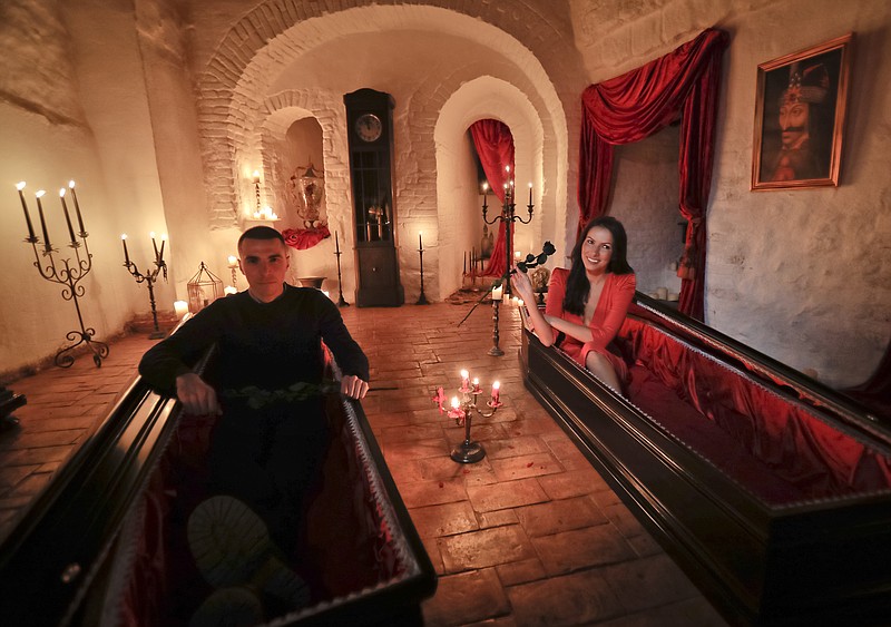 
              Tami Varma and her brother Robin, the grandchildren of Devendra Varma, a scholar of English gothic tales and an expert in vampire lore, pose in coffins at Bran Castle, in Bran, Romania, Monday, Oct. 31, 2016. A Canadian brother and sister are passing Halloween night curled up in red velvet coffins in the Transylvanian castle that inspired the Dracula legend, the first time in 70 years anyone has spent the night in the gothic fortress after they bested 88,000 people who entered a competition hosted by Airbnb to get the chance to dine and sleep at the castle in Romania. (AP Photo/Vadim Ghirda)
            