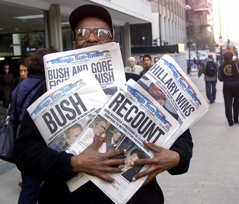 
              FILE - In this Nov. 8, 2000 file photo, Willie Smith holds four copies of the Chicago Sun-Times, each with a different headline, in Chicago, reflecting a night of suspense, drama and changes in following the presidential race between Vice President Al Gore and Texas Gov. George W. Bush. What happens if America wakes up on Nov. 9 to a disputed presidential election in which the outcome turns on the results of a razor-thin margin in one or two states, one candidate seeks a recount and the other goes to court? (AP Photo/Charles Bennett, File)
            