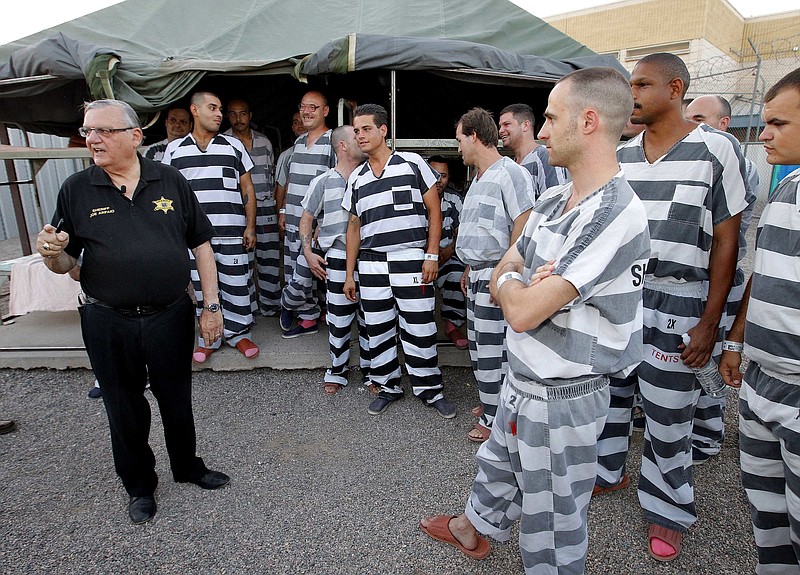 
              FILE - In this , June 23, 2012, file photo, inmates gather next to Maricopa County Sheriff Joe Arpaio as he walks through a Maricopa County Sheriff's Office jail called "Tent City" in Phoenix. Arpaio disbanded a SWAT team that focused on handling dangerous jail inmates at a time when the elite unit was in high demand due to a spike in assaults by inmates on guards, records show. Arpaio folded the Special Response Team in September as part of $8 million in budget cuts to cover skyrocketing legal costs from a racial-profiling case against the sheriff's office.  (AP Photo/Matt York, File)
            