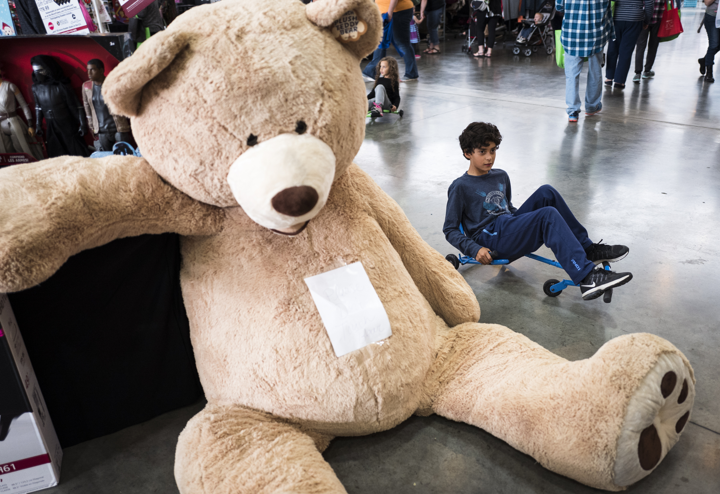 Ezequiel Berck rides a wheeled scooter past a large stuffed bear at the Times Free Press's HoHo Expo at the Chattanooga Convention Center on Saturday, Nov. 5, 2016, in Chattanooga, Tenn. The holiday expo features more than 200 vendors as well as children's entertainment and continues Sunday.