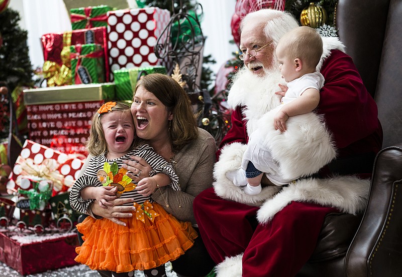 Kathryn Tucker reacts as she is photographed with Santa along with her mother Kristin, center, and brother Patrick, right, at the Times Free Press's HoHo Expo at the Chattanooga Convention Center on Saturday, Nov. 5, 2016, in Chattanooga, Tenn. The holiday expo features more than 200 vendors as well as children's entertainment and continues Sunday.