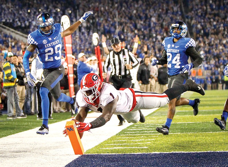 Georgia running back Sony Michel dives into the end zone for a touchdown after getting past Kentucky cornerback Derrick Baity, left, and defensive back Blake McClain, right, during the second half of an NCAA college football game Saturday, Nov. 5, 2016, in Lexington, Ky. Georgia won 27-24. (AP Photo/David Stephenson)