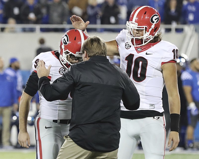 Georgia kicker Rodrigo Blankenship, left, is congratulated by coach Kirby Smart and quarterback Jacob Eason following his game-winning, 25-yard field goal Saturday at Kentucky.