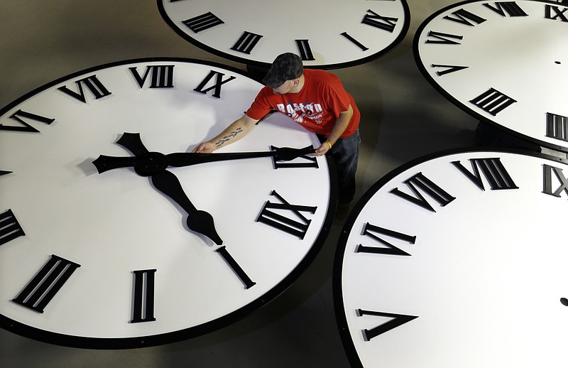 
              In this Thursday, Nov. 3, 2016 photo, Dan LaMoore sizes hands for an 8-foot diameter silhouette clock at Electric Time Co., in Medfield, Mass. Daylight saving time ends at 2 a.m. local time Sunday, when clocks are set back one hour. (AP Photo/Elise Amendola)
            