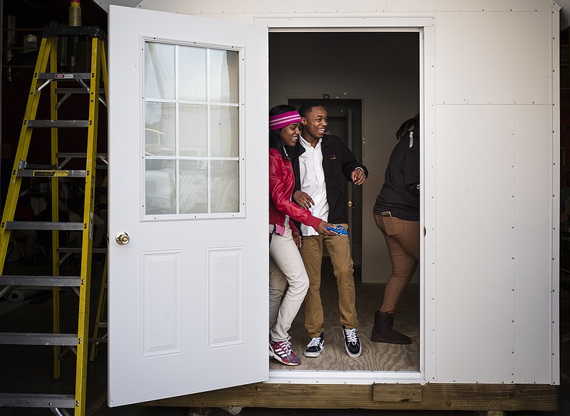 Demetrius Williams, right, and Tadayja Toran stand in the doorway of a tiny house under construction at Tyner Academy.