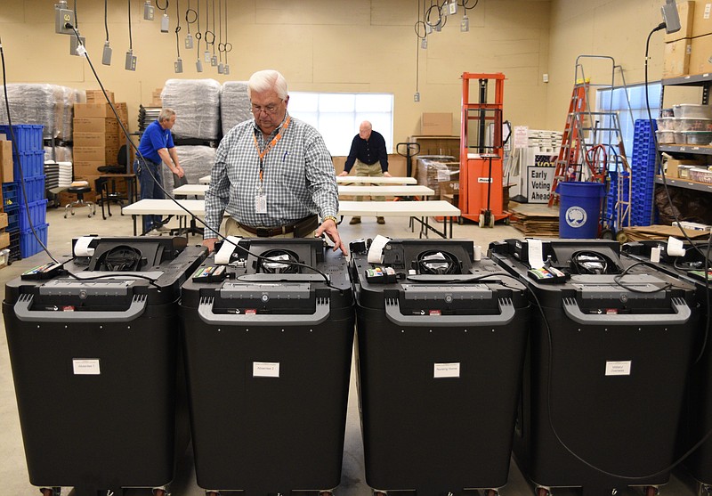 Bill Adams sets up the machines Monday, Nov. 7, 2016 at the Hamilton County Election Commission that will count absentee ballots after they are verified.