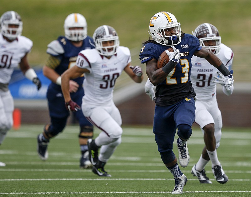 UTC running back Richardre Bagley breaks away from Fordham defenders Chris Geisller (90) and Caleb Ham (31) in the first half of the Mocs' FCS playoff football game against Fordham at Finley Stadium on Saturday, Nov. 28, 2015, in Chattanooga, Tenn.