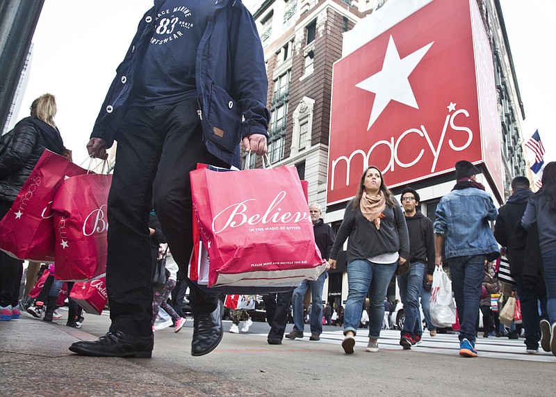 
              FILE - In this Friday, Nov. 27, 2015, file photo, shoppers carry bags as they cross a pedestrian walkway near Macy's in Herald Square, in New York. Thanksgiving Day shopping it isn't going away and some stores are rethinking their strategies on whether it makes sense to be open. Many major mall operators and big retailers such as Toys R Us, J.C. Penney, and Macy's are sticking with being open. Others, including the Mall of America, are closing for Thanksgiving. (AP Photo/Bebeto Matthews, File)
            