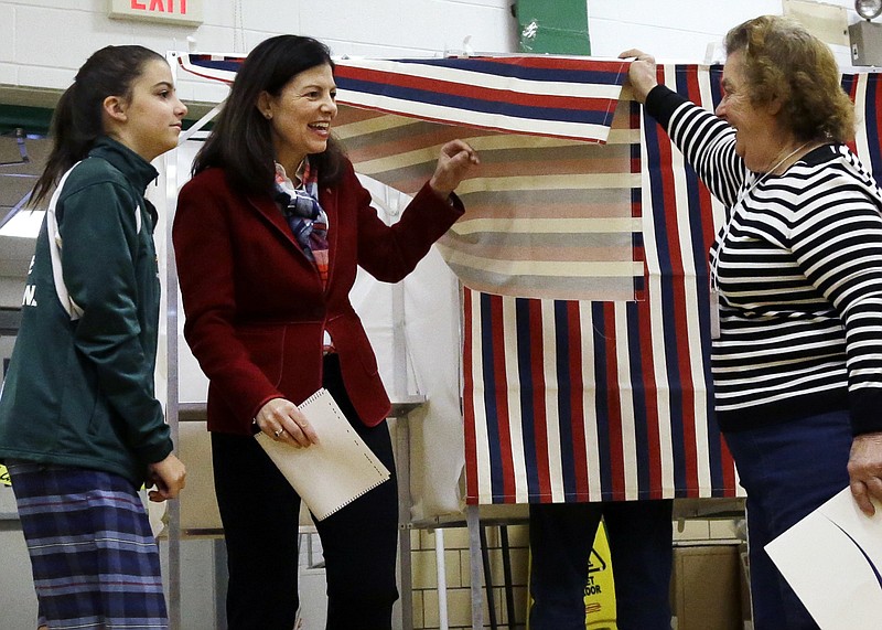 
              A poll worker lifts the curtain as Sen. Kelly Ayotte, R-N.H., center, leaves the voting booth with her daughter, Kate, Tuesday, Nov. 8, 2016, at Charlotte Avenue Elementary School in Nashua, N.H. (AP Photo/Elise Amendola)
            