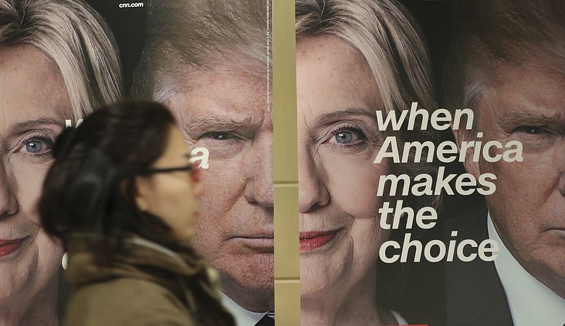 
              A woman walks by banners of Democratic presidential candidate Hillary Clinton and Republican presidential candidate Donald Trump during an election watch event hosted by the U.S. Embassy in Seoul, South Korea, Wednesday, Nov. 9, 2016.  The United States headed for the polls to vote for their new president on Tuesday. (AP Photo/Lee Jin-man)
            