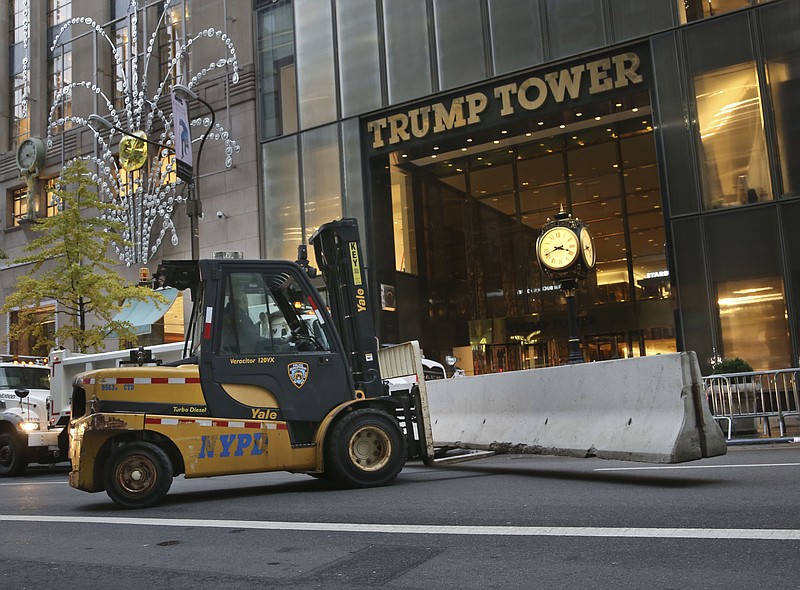 
              Police officers help to install concrete barriers around Trump Tower, the home of President-elect Donald Trump, in New York, Wednesday, Nov. 9, 2016.  A day after Trump, against all odds, won election as America's 45th president, Hillary Clinton on Wednesday lamented that the nation proved to be "more divided than we thought" but told supporters: "We owe him an open mind and a chance to lead." (AP Photo/Seth Wenig)
            
