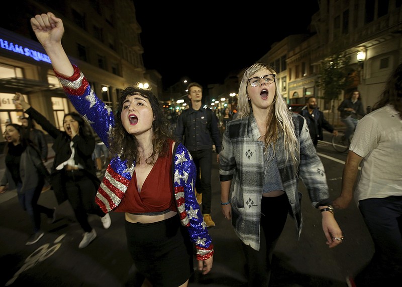 Madeline Lopes, left, and Cassidy Irwin, both of Oakland, march with other protesters in downtown Oakland, Calif., early Wednesday, Nov. 9, 2016. President-elect Donald Trump's victory set off multiple protests. (Jane Tyska/Bay Area News Group via AP)