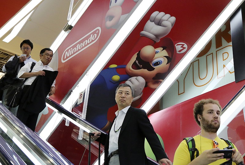 
              FILE - In this July 13, 2015, file photo, shoppers ride on an escalator under Nintendo's Super Mario characters at an electronics store in Tokyo. Nintendo Co. is ending sales in Japan of its Wii U home console “soon,” although it’s not saying exactly when, and similar announcements are expected in other regions. The Wii U, which went on sale from late 2012, is being replaced by Switch, set to go on sale globally in March 2017. Nintendo says it will show it to reporters in Japan on Jan. 13. (AP Photo/Koji Sasahara, File)
            
