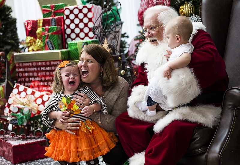 Kathryn Tucker reacts as she is photographed with Santa along with her mother Kristin, center, and brother Patrick, right, at the Times Free Press's HoHo Expo at the Chattanooga Convention Center on Saturday, Nov. 5, 2016, in Chattanooga. The holiday expo features more than 200 vendors as well as children's entertainment and continues Sunday.