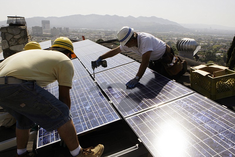 
              FILE - In this March 23, 2010, file photo, installers from California Green Design install solar electrical panels on the roof of a home in Glendale, Calif. The Obama administration is boosting the development of solar and wind energy on public lands. A final rule announced by the Interior Department on Thursday, Nov. 10, 2016, would create a new leasing program on public lands and encourage development in areas where it would have fewer effects on the environment.  (AP Photo/Reed Saxon, File)
            