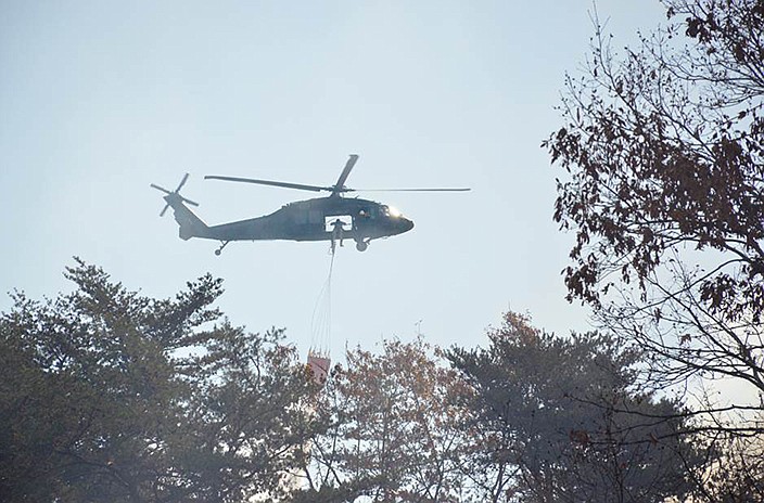 National Guard helicopters continue to drop water over the fire.