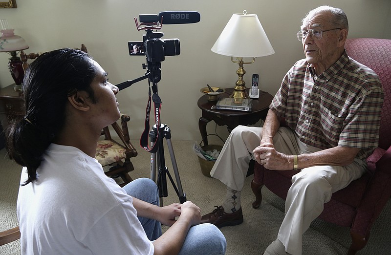 This Oct. 17, 2016 photo Rishi Sharma interviews World War II veteran William Hahn, at his home in Los Angeles. Sharma's heroes aren't sports or movie stars, or any other kind of stars; they're the U.S. combat veterans who won World War II. And the Southern California teen is alarmed that even the youngest of them are now in their 90s, and they're dying each day by the hundreds. Sharma has launched a campaign to try to ensure the legacy of each World War II combat veteran. He's on a mission to interview one every day while he still can. (AP Photo/Nick Ut)