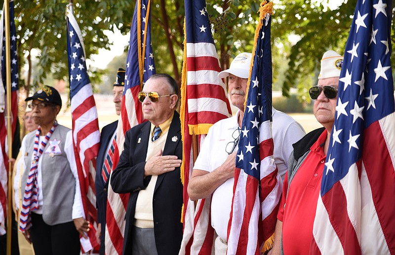 Veterans stand with flags during massing of the colors in the Veterans Day program Friday, Nov. 11, 2016 at the National Cemetery. 