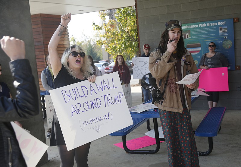 Ashley Williams, left, and Asher P. Larson go over chants with demonstrators at an anti-Donald Trump protest organized by Occupy Chattanooga at Renaissance Park on Saturday, Nov. 12, 2016, in Chattanooga, Tenn. Demonstrators marched from the park to the courthouse downtown to protest President-elect Trump.