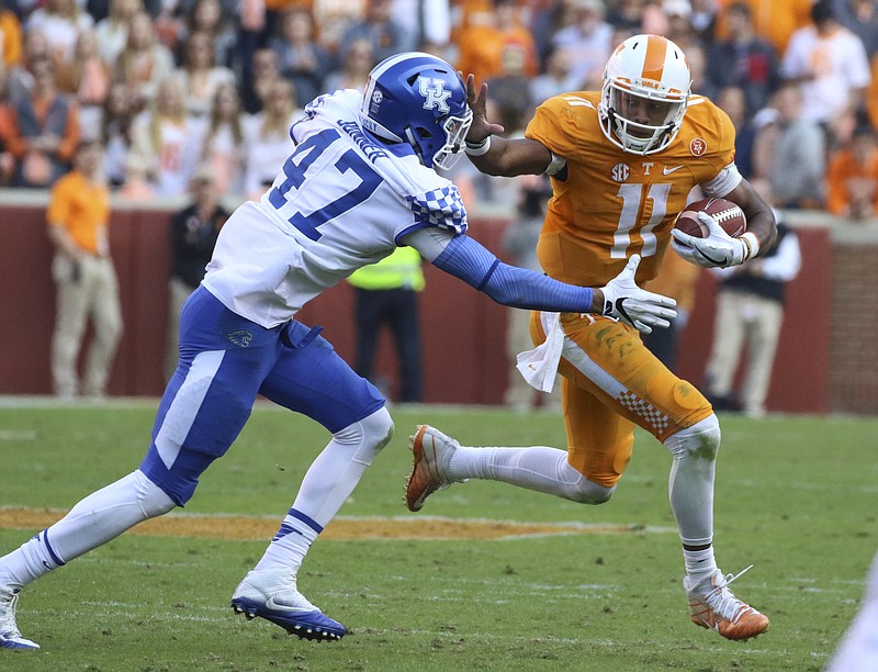 Staff Photo by Dan Henry / The Chattanooga Times Free Press- 11/12/16. Tennessee quarterback Joshua Dobbs (11) stiff arms Kentucky's Jordan Bonner (47) while gaining yardage during the fourth quarter of play. The Tennessee Volunteers won over the Kentucky Wildcats with a final score of 49-36 at Neyland Stadium in Knoxville, Tenn., on Saturday, November 12, 2016. 