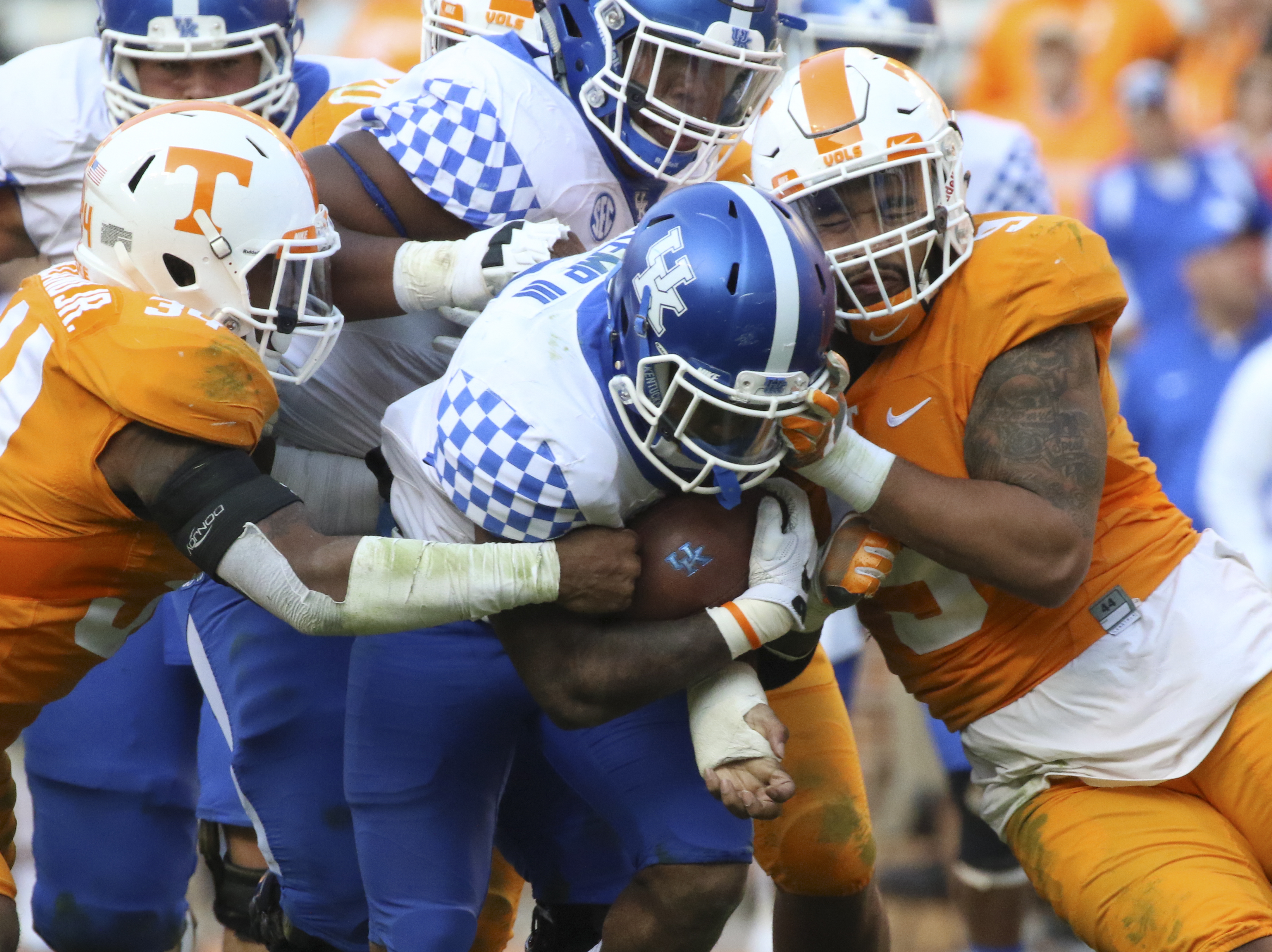Staff Photo by Dan Henry / The Chattanooga Times Free Press- 11/12/16. Tennessee's Darrin Kirkland Jr. (34) and Derek Barnett (9) collide with Kentucky's William Mahone III (32) during the fourth quarter of play. The Tennessee Volunteers won over the Kentucky Wildcats with a final score of 49-36 at Neyland Stadium in Knoxville, Tenn., on Saturday, November 12, 2016.