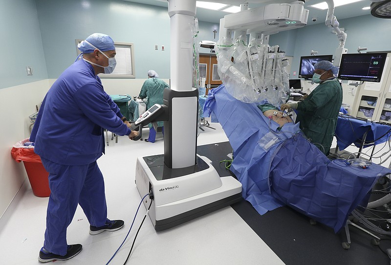 Staff Photo by Dan Henry / The Chattanooga Times Free Press- 11/2/16. Circulation Nurse Mark Huber assists as a team attaches a DaVinci Xi robot to a patient while performing a robotic assisted laparoscopic prostatectomy at CHI Memorial Hospital on November 2, 2017.
