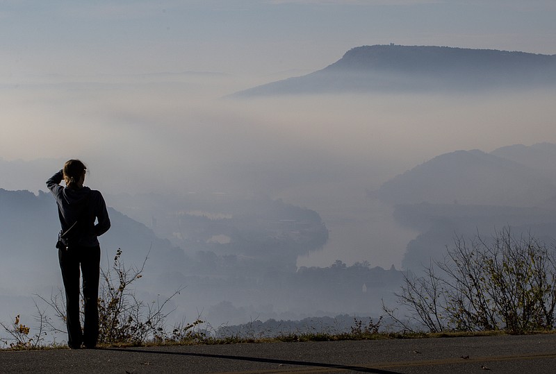 Grace Mynatt stands atop Signal Mountain and looks off toward Lookout Mountain as smoke from wildfires collected in Chattanooga Valley last week. Staff Photo by Dan Henry / The Chattanooga Times Free Press