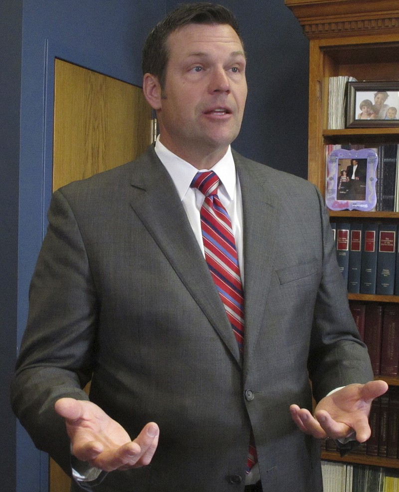 In this Wednesday, Nov. 2, 2016 photo, Kansas Secretary of State Kris Kobach answers questions from reporters following a meeting of the State Elections Board in Topeka, Kan. Kobach is predicting that a record number of more than 1.3 million Kansas voters will cast ballot in this year's general election (AP Photo/John Hanna)