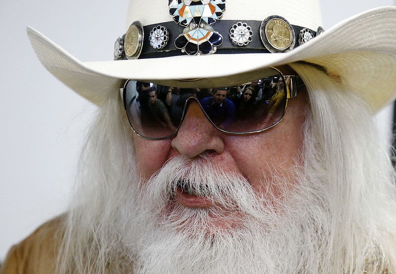 In this Jan. 29, 2013, file photo, reporters are reflected in the sunglasses of Leon Russell as he answers a question at a news conference in Tulsa, Okla. Russell, who sang, wrote and produced some of rock 'n' roll's top records, has died. (AP Photo/Sue Ogrocki, File)