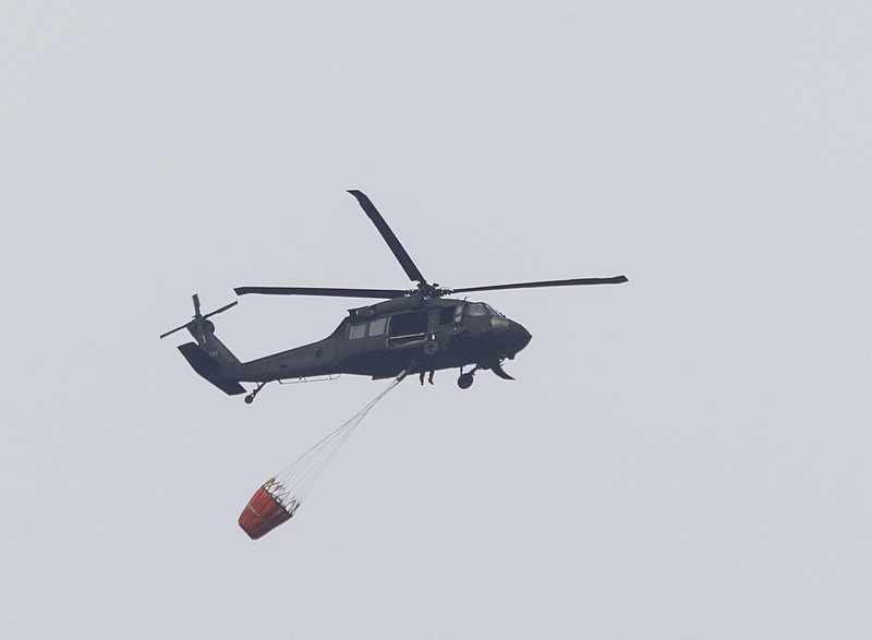 A helicopter returns to collect water Friday, Nov. 11, 2016, in Soddy-Daisy, Tenn. There are currently 55 wildfires in the Cumberland Plateau area and have been an estimated 30,000 acres of wildfire to date this year, according to the Tennessee Department of Agriculture.