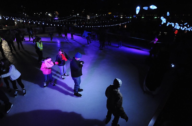 The ice skating rink at night is lit by strands of LED lights and colored spots on the corners at Chattanooga Green.