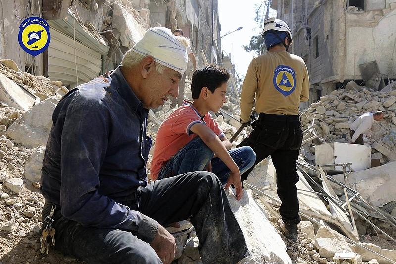 
              FILE -- In this Oct. 11, 2016 file photo, provided by the Syrian Civil Defense group known as the White Helmets, residents sit amongst rubble in rebel-held eastern Aleppo, Syria. Syrian opposition activists say airstrikes have hit rebel-held eastern Aleppo on Tuesday, Nov. 15, 2016, for the first time in three weeks, fearing it could signal the start of a new government offensive in the northern city. The Britain-based Syrian Observatory for Human Rights says that airstrikes struck three neighborhoods. It had no immediate word on casualties. (Syrian Civil Defense- White Helmets via AP, File)
            
