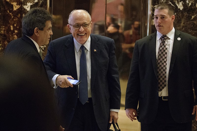 Former New York Mayor Rudy Giuliani, center, smiles as he leaves Trump Tower, Friday, Nov. 11, 2016, in New York. (AP Photo/Evan Vucci)